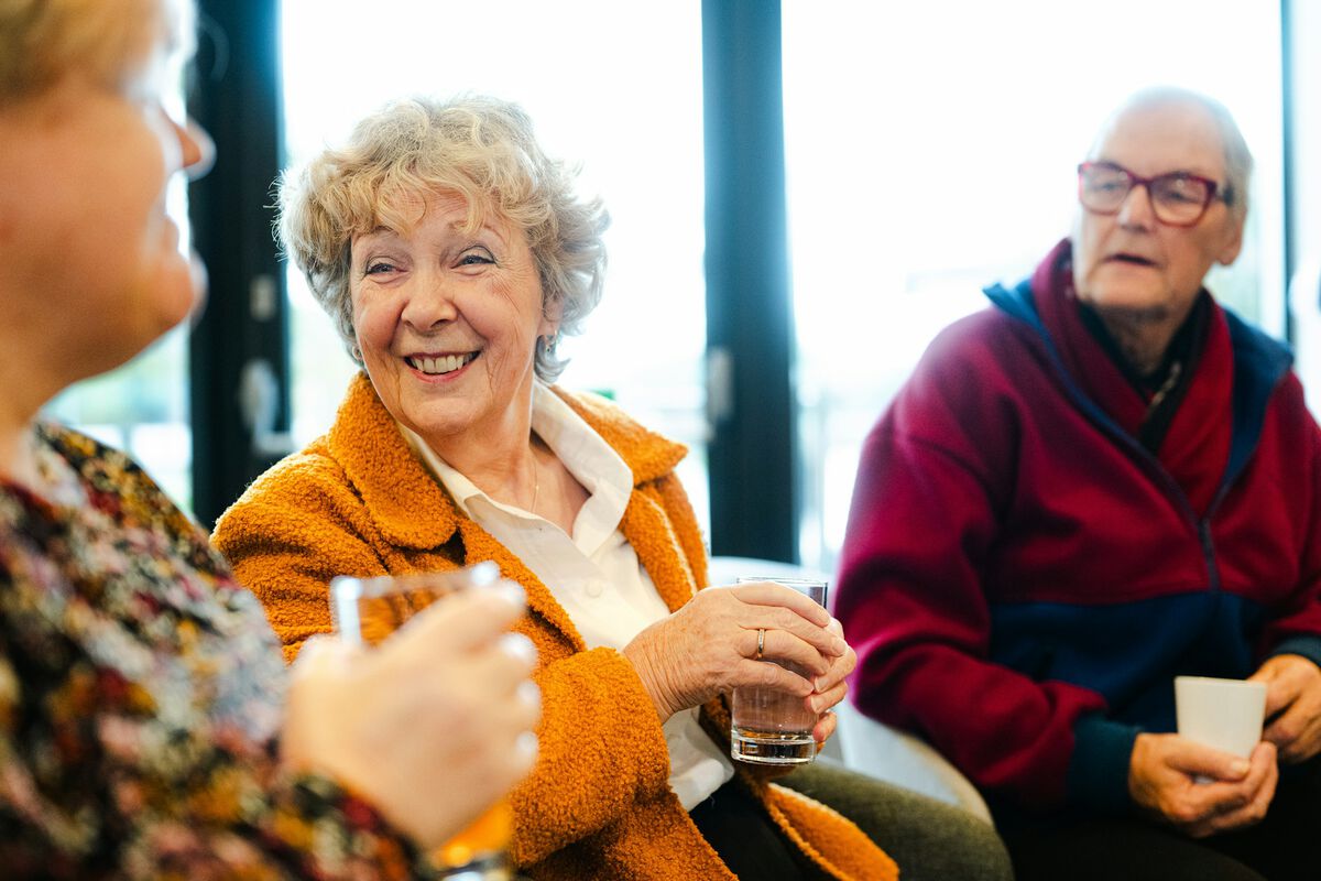 Friends in their sixties laughing over drinks